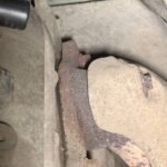 Чашка кофе и круассан на деревянном столе в лучах утреннего солнца
